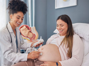 Pregnant woman and doctor with heart rate monitor to illustrate prenatal care