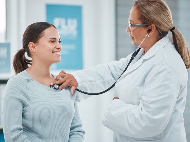 women's health specialist doctor using stethoscope to examine patient