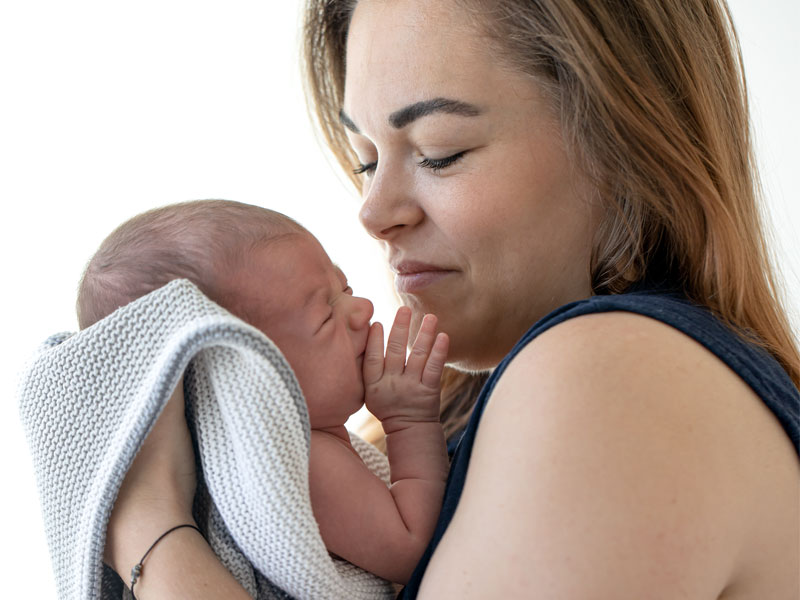 Young mother with newborn, to illustrate how to balance hormones after pregnancy