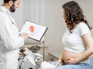 Doctor with pregnant woman to illustrate checkups during second trimester of pregnancy