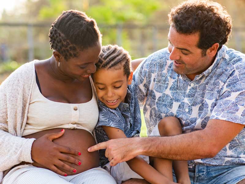 Family group showing pregnant mum to illustrate second trimester of pregnancy