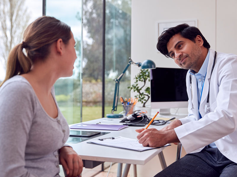 doctor and female patient in discussion to illustrate an annual well-woman exam