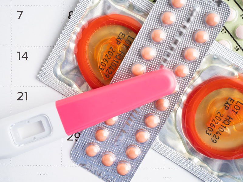 contraceptive pills, condoms, and a pregnancy test kit to illustrate birth control