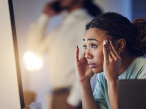 Stressed woman at computer to illustrate possible cause of hormone imbalance