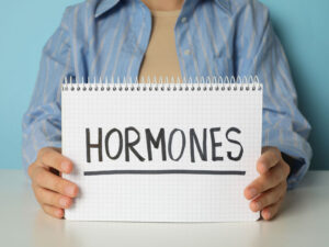 the word hormones held in human hands