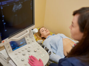 Consultant making an ultrasound scan of a pregnant woman