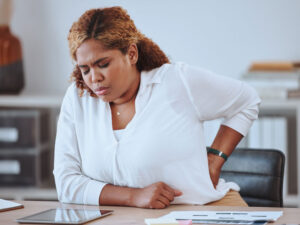 woman with back pain to illustrate the need to prevent osteoporosis after menopause