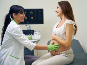 Gynecologist examining a woman to monitor healthy pregnancy progress during three trimesters