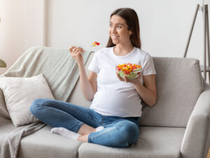 Woman with healthy dish of food to illustrate tips for a healthy pregnancy diet