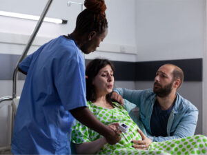 Woman in labor with husband and medical assistant helping to illustrate preparation for labor