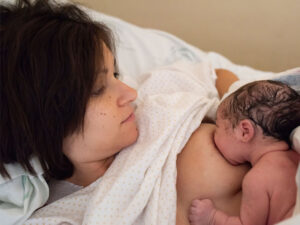 Woman breastfeeding her newborn daughter to illustrate postpartum care in a healthy pregnancy