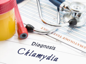 Urine container and diagnosis form naming chlamydia to illustrate the sexually transmitted disease in pregnancy