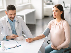 gynecologist testing blood pressure in pregnant woman