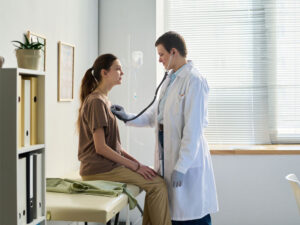 Primary care doctor using a stethoscope to examine a patient