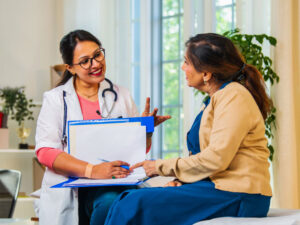 doctor explaining something to an adult to illustrate what an internist is compared to a primary care doctor