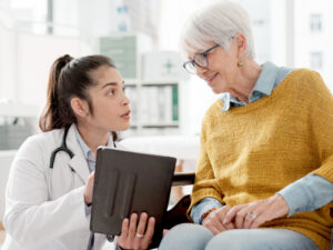 young docotr discussing health with an older woman to illustrate having both a primary care provider and a gynecologist throughout life