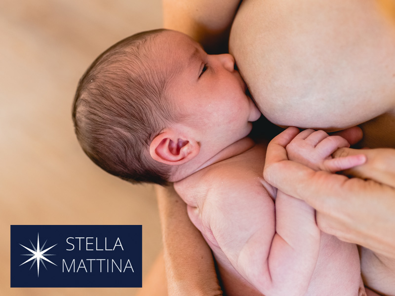 Close-up of newborn baby sucking on a nipple to illustrate benefits of breastfeeding