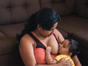 Mom feeding young child to illustrate top health benefits for breastfeeding mothers