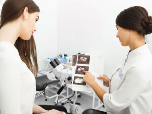 gynecologist pointing at breast images to illustrate discussing breast cancer testing results