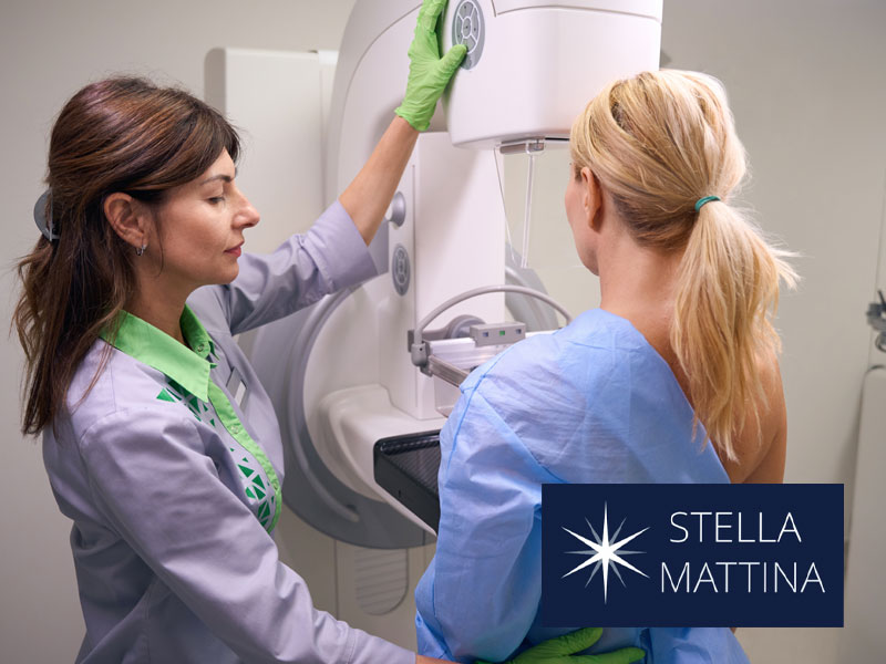 Radiologist preparing a woman for a mammogram screening