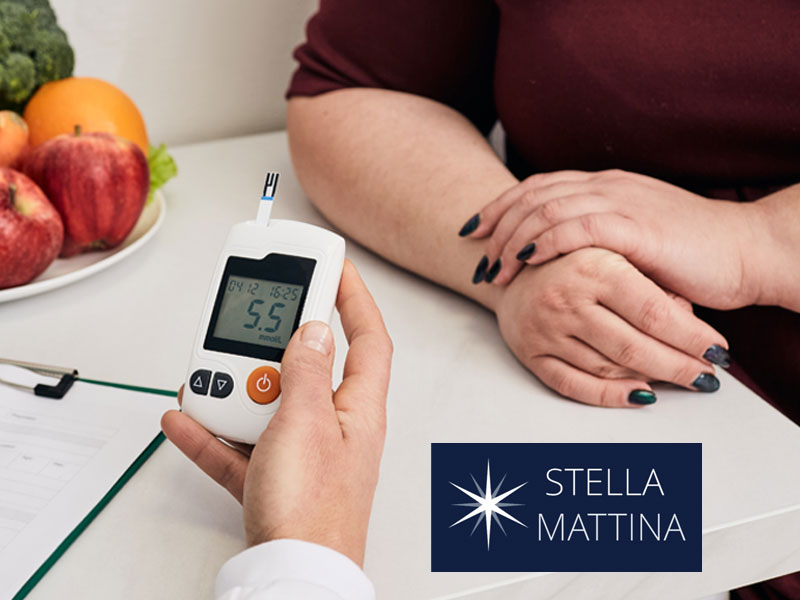 A doctor's hand holds a blood glucose meter and sits opposite a partially seen woman - to illustrate screening for diabetes