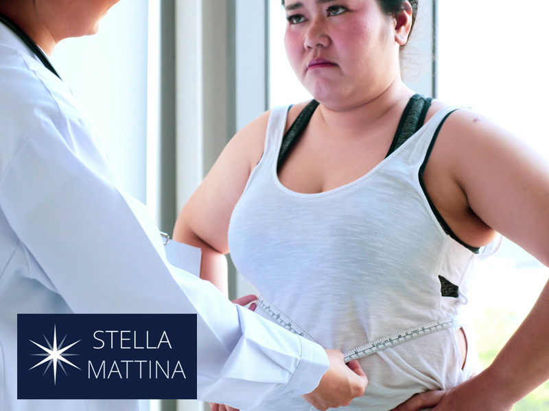 doctor measuring the waist of a woman to illustrate the hormone connection to weight loss