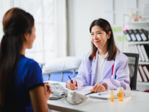 doctor taking notes while talking to a patient to illustrate considering how fat affects hormones