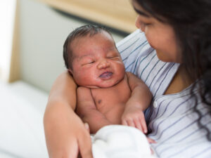 woman holding her newborn to illustrate how breastfeeding can make return of periods irregular or absent