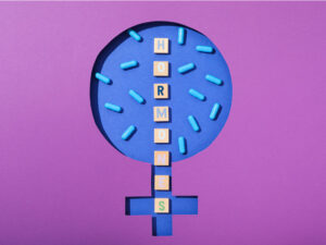Graphic design of the usual female symbol with the letters of HORMONE written on it to illustrate how hormones affect periods after birth