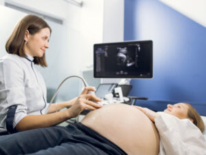 Young pregnant woman undergoing an ultrasound scan to illustrate advanced testing when a pregnancy is high risk