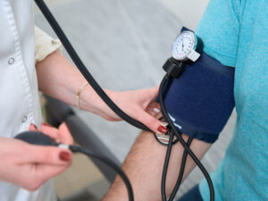 close-up of doctor taking blood pressure with an arm wrap - to illustrate what can make pregnancy high risk